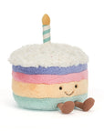 Peluche Amuseables Rainbow Birthday Cake Jellycat, de face, avec sa bougie