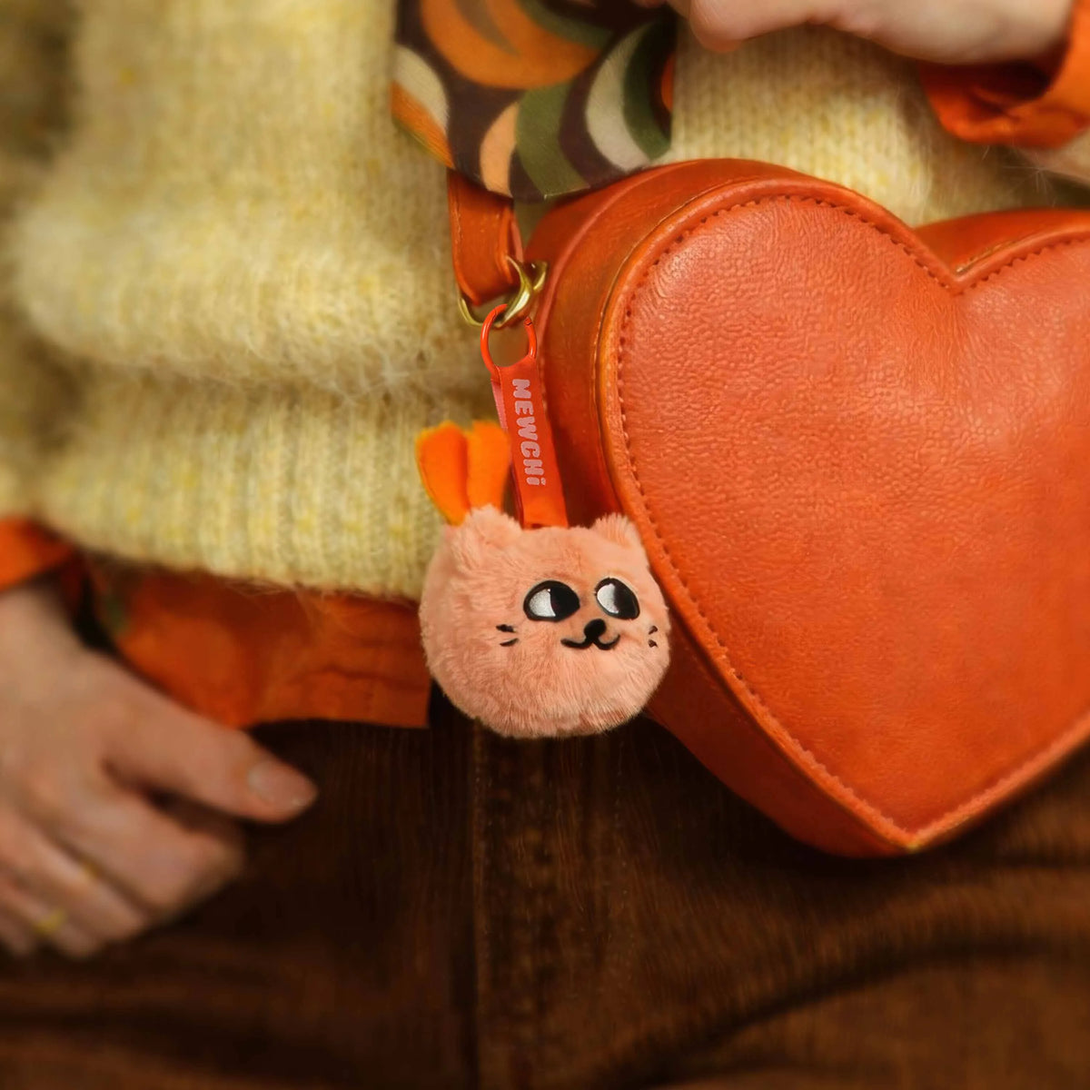 Mini peluche porte-clés Mewchi Sweet Buddies OMY accrochée à un sac orange